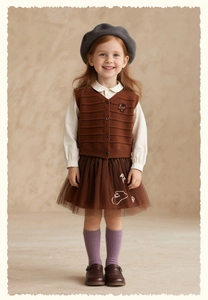 Detail view of girl's knit vest with flower embroidery and layered brown tulle skirt