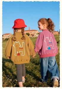 Detail of girls cartoon cat jackets showing mustard yellow and pink textured fabric