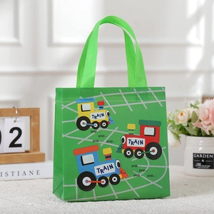 Close-up of green non-woven gift bag with colorful cartoon trains and sturdy handles