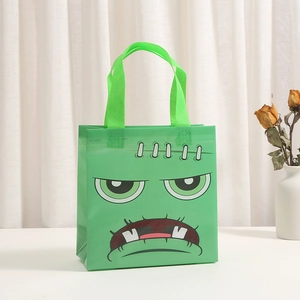 Green non-woven Halloween gift bag with a Frankenstein monster face print and sturdy handles