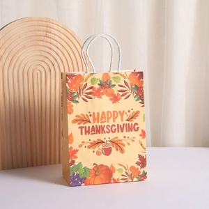 Warm yellow Happy Thanksgiving paper gift bag with autumn leaves, pumpkin, and rope handles