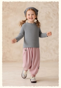 Detail of pink floral embroidery on girls' casual joggers paired with a knit sweater