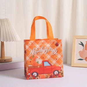 Detail of Happy Thanksgiving gift bag with red truck pumpkin design and orange handles