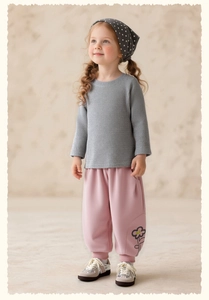 Detail of pink floral joggers with grey ribbed knit sweater and polka dot headband