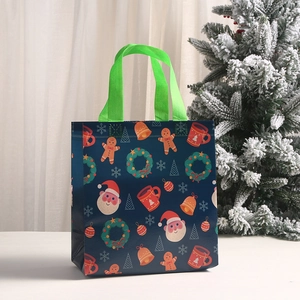 Christmas non-woven gift tote bag featuring Santa and gingerbread man on dark blue base