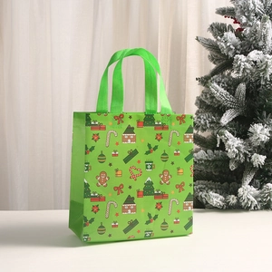 Green non-woven Christmas gift bag with festive gingerbread and candy cane patterns