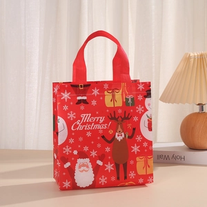 Detail of red Merry Christmas non-woven gift bag with Santa and reindeer prints