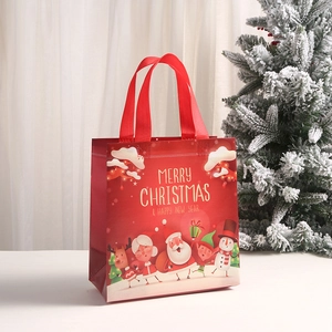 Red Christmas non-woven gift bag featuring Santa and reindeer illustrations with gold handles