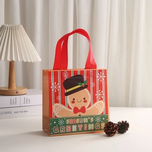 Festive red non-woven Christmas gift bag with gingerbread man and snowflake patterns