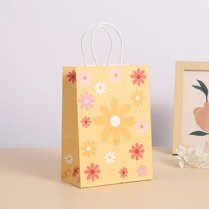 Bolsa de papel para regalo con estampado de margaritas y asas de papel blancas