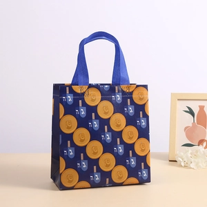 Blue Hanukkah non-woven gift bag with golden coins and dreidel print for festive shopping