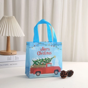 Close-up of non-woven Christmas gift bag with festive red truck and Xmas tree design