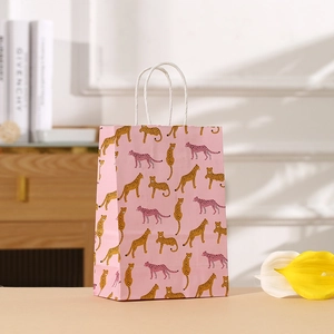 Bolsa de regalo de papel rosa con estampados de guepardo y asas de cuerda blanca trenzada