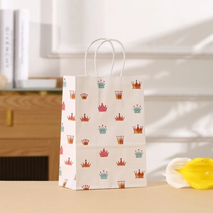 Bolsa de regalo de papel blanco con estampados de coronas coloridas y asas de cuerda blanca