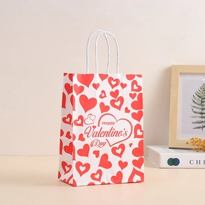 Close-up of white paper gift bag with red hearts and Happy Valentine's Day text