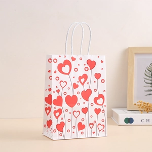 Close-up of white gift bag with red heart patterns and white rope handle detail