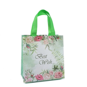 Floral non-woven gift bag with green handles and Best Wish text shown from a 45-degree angle