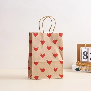 Brown kraft gift bag with winged red hearts and paper handles for Valentine party favors