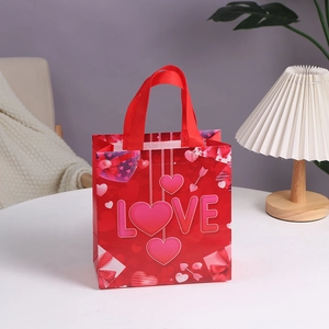 Red non-woven Valentine gift bag with LOVE typography and heart patterns and red handles