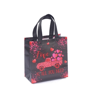 Black non-woven Valentine gift bag with red truck carrying pink hearts and Love text