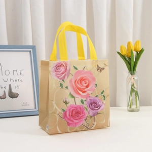 Champagne non-woven gift bag with pink floral rose patterns and yellow handles