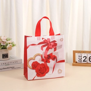 Sac cadeau en non-tissé rouge et blanc avec motifs de roses et poignées renforcées