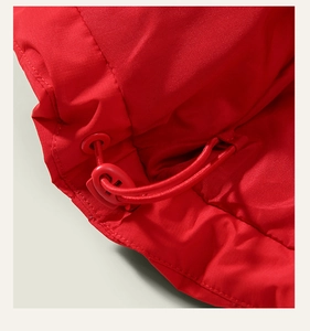 Close-up of red winter down jacket hem with adjustable drawstring and toggle closure