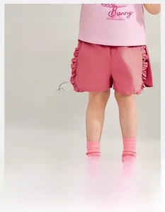 Détail de short d'été fille rose vif avec un design doux à bords ondulés
