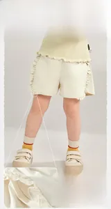 Détail du short en coton pour filles montrant les coutures précises et les bords à volants
