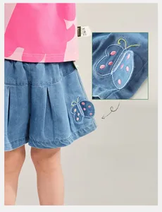 Detailed view of 3D butterfly embroidery on girls' denim skirt with pleated hem design