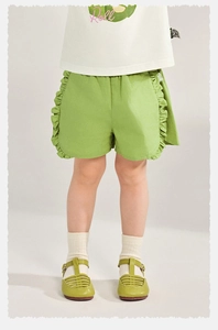Détail du short vert à volants pour fille avec t-shirt blanc à logo pour l'été
