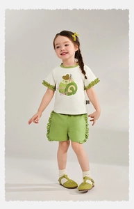 Détail du t-shirt blanc pour filles avec imprimé gâteau et short à volants verts