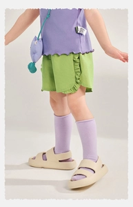 Détail de la tenue d'été pour filles avec haut violet et short vert à volants