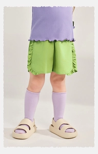 Détail du short vert à volants pour fille assorti à un haut violet et des sandales