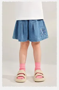 Detail of girl's denim shorts featuring butterfly embroidery and pleated wide-leg design