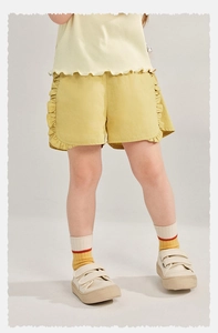 Détail d'un short jaune gingembre avec taille élastique et volants étagés doux