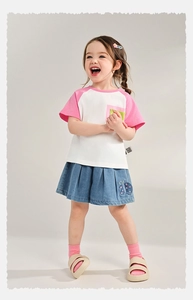 Close-up of pink raglan sleeve t-shirt and denim pleated skirt with butterfly embroidery