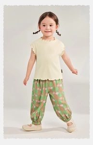 Close-up of children's summer set with yellow ribbed tank top and printed wide-leg pants