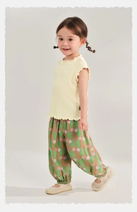 Detail of kids breathable summer outfit featuring dot pattern harem pants and ruffle vest