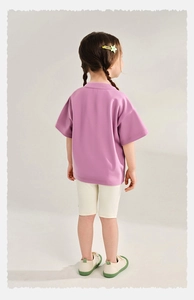 Vista trasera de camiseta de algodón lavanda y pantalones de ciclista beige para niñas