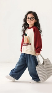 Detail of girls wide leg denim pants with casual red and cream sweatshirt outfit