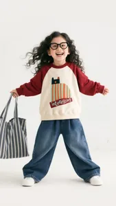 Detailed shot of a girls' casual outfit featuring a cat print sweatshirt and wide-leg jeans