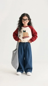 Detail of girls wide-leg denim pants paired with a color-block sweatshirt and white shoes