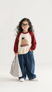 Detail of girls red and white color-block sweatshirt with dark blue wide-leg jeans