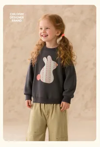 Close-up of a grey girls' sweatshirt with a cute rabbit patch and khaki casual pants