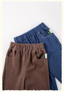 Detail van de elastische taillebanden en zijzakken op de blauwe en bruine katoenen broek