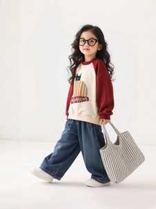 Girls wide-leg jeans paired with a raglan sleeve cat print sweatshirt in a retro style