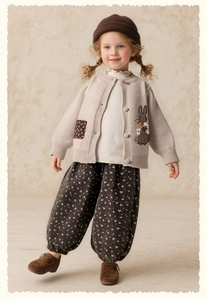 Detail of girl's beige cardigan with brown rabbit embroidery and floral harem pants