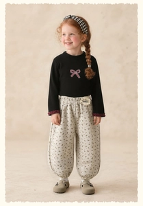Detail of baby girl floral lantern pants with a cute cookie flower patch and elastic waist