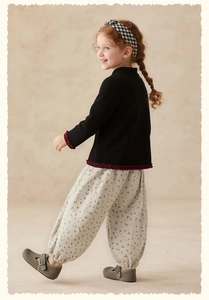 Detail of girls floral casual pants with comfortable red ruffled trim on long sleeves